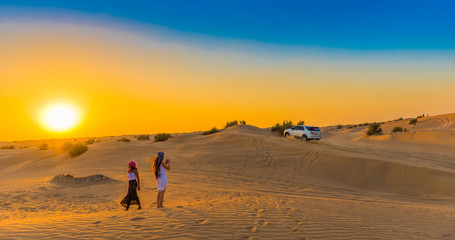 Fototapeta na wymiar DUBAI, UNITED ARAB EMIRATES - DECEMBER 13, 2018: Jeep safari at sunset over sand dunes in Dubai Desert Conservation Reserve. Copy space for text.