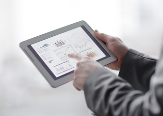 close up. businessman is analyzing financial report using digit