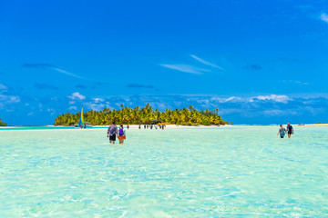 People walking true turquoise sandbank, Aitutaki island, Cook Islands, South Pacific. Copy space for text...