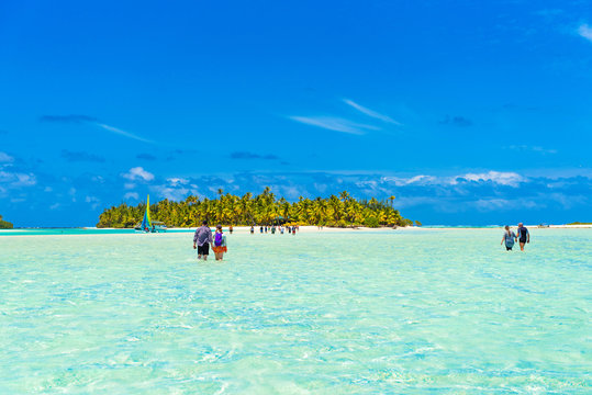 People walking true turquoise sandbank, Aitutaki island, Cook Islands, South Pacific. Copy space for text...