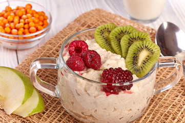 porridge with fruit on wooden background