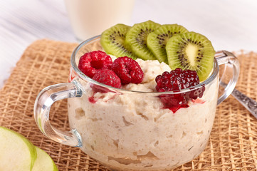 porridge with fruit on wooden background