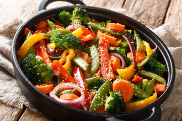 Quick-fried vegetables with sesame in Asian style close-up in a bowl, horizontal