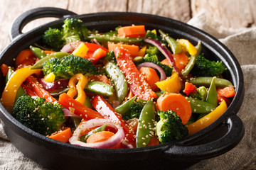 Fried vegetable mix with sesame close-up in a bowl on the table, horizontal