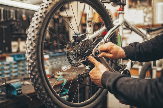Bicycle mechanic in a workshop in the repair process. - Powered by Adobe