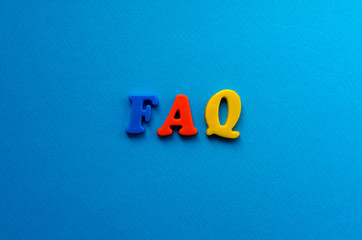 abbreviation FAQ from plastic magnetic letters on blue background