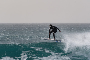 surfer against a deep blue wave 