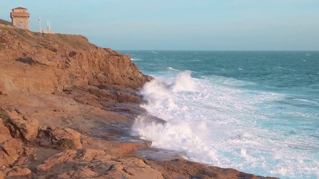 Onde del mare che si infrangono sulla scogliera rocciosa al rallentatore.