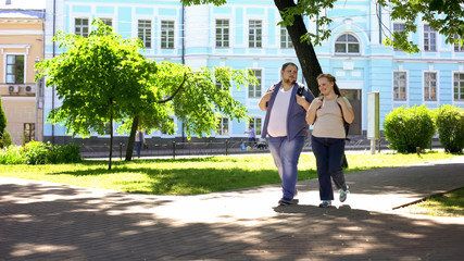 Fat student couple walking in city park, urban date, leisure time, friendship
