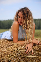 girl in a field on the background of hay