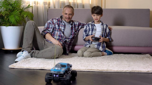 Kid learning to drive car on radio control, expensive gift from sunday father