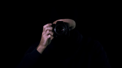 Man in black mask making photos by camera, secret information, demanding ransom