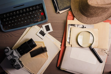 Investigator desk with confidential documents, camera, magnifying glass, vintage typewriter and...