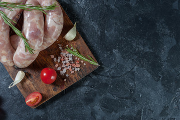 Raw sausages on cutting board