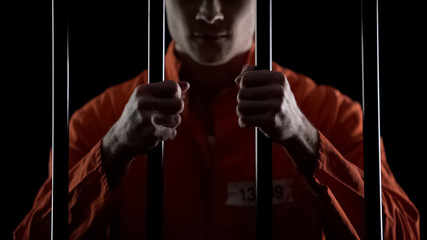 Aggressive inmate holding prison bars, unfairly judged, court sentence appeal