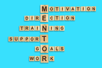 Concept Mentoring. Words written on a wooden block. Blue background. Business. Leadership