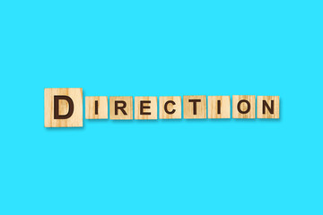 Direction. Words written on a wooden block. Blue Background Isolated. Business concept.