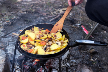 Potatoes with vegetables in a pan, fried on fire