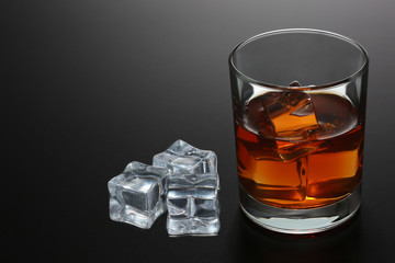 Glass of whiskey on black gradient background