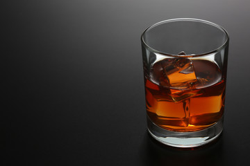 Glass of whiskey on black gradient background