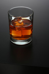 Glass of whiskey on black gradient background