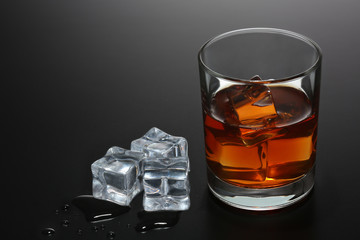 Glass of whiskey on black gradient background