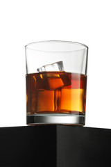 Glass of whiskey on black table isolated over white