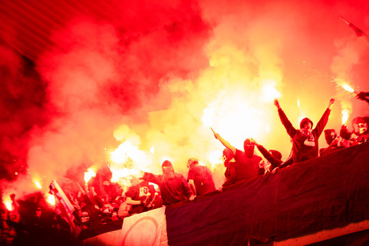 football hooligans with mask holding torches in fire
