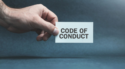 Man hand holding card. Code of Conduct