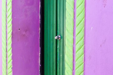 A green door of a violet house with green decorations (Ari Atoll, Maldives)