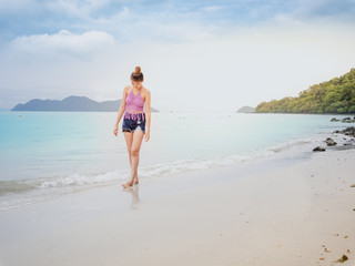 Fototapeta na wymiar Summer beach concept from relaxed woman in bikini enjoying walk on tropical beach at sea Thailand.