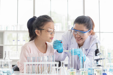 Image of woman teacher and girl student in lab science class. Young girl excited in lab class with...