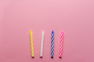  multicolored candles for cake on paper background