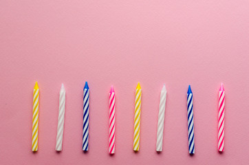  multicolored candles for cake on paper background