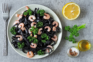 Black noodles with shrimps and greens. Black food. Vegetarian trend lunch.