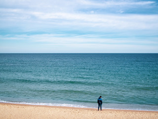 Fototapeta na wymiar Lonely thinking young man standing on the beach in sunny day, copy space