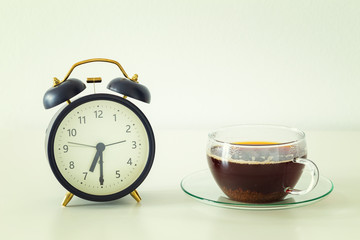 Alarm clock and a glass of tea on the table