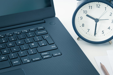  computer and an alarm clock measuring the time running away. The concept of urgent deadlines at...