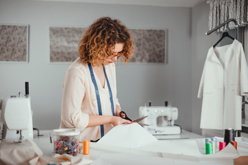 Professional female tailor over work desk at fashion design workshop