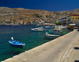 Fototapeta na wymiar Simi island port, Greece. Summer day view to traditional greek island port with boats.