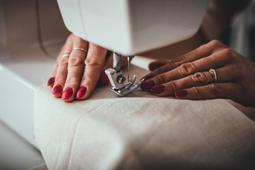 Professional dressmaker using sewing machine, close up