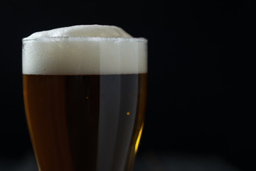 Glass of lager on a dark background