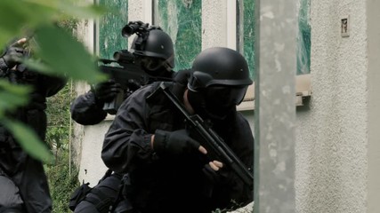 A Special Force Team storm in a bedraggled house.