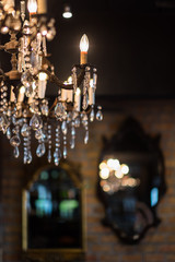 Part of chandelier with blurry background of mirrors
