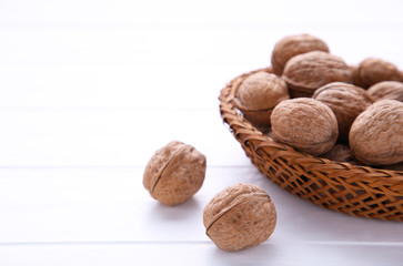 Walnuts kernels in basket on white wooden background. Walnuts kernels on white wooden table