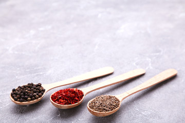 Spices mix on wooden spoons on a grey background. Top view