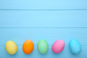 Colorful easter eggs on a blue background, flat lay