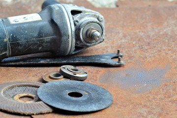 Fototapeta na wymiar Grinder and cutting wheels on a rusty sheet of metal.