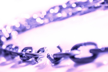Broken chain on white surface, selective focus shallow depth of field