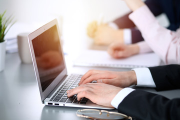 Fototapeta premium Group of business people working together in office. Man hands typing on laptop computer